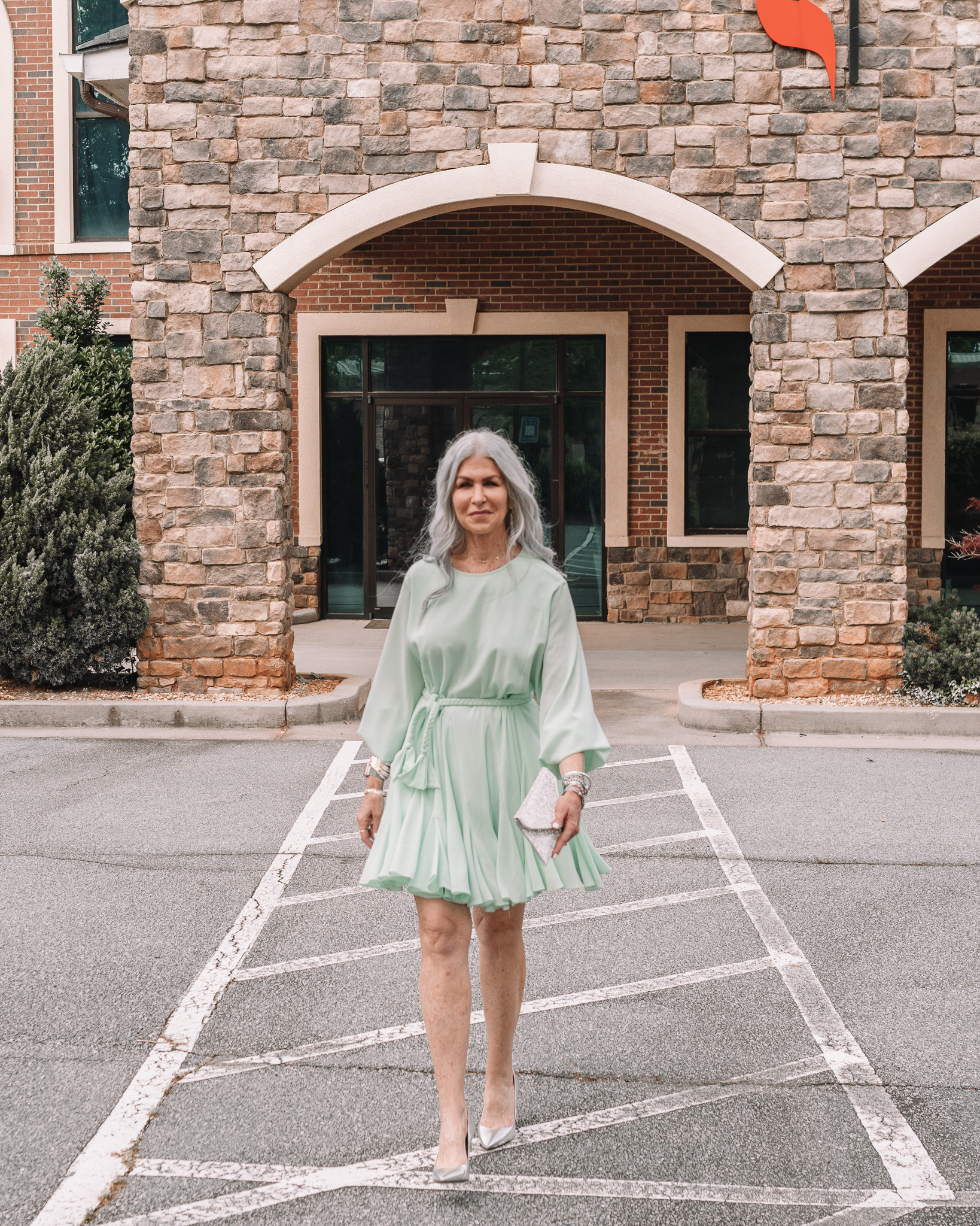 lisa in a mint green above the knee formal wedding guest dress and silver pumps