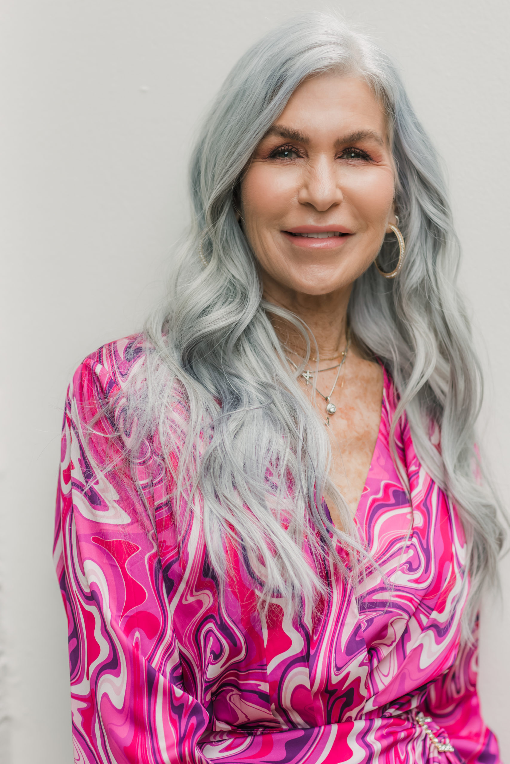 close up of silver hair woman in pink wrap dress