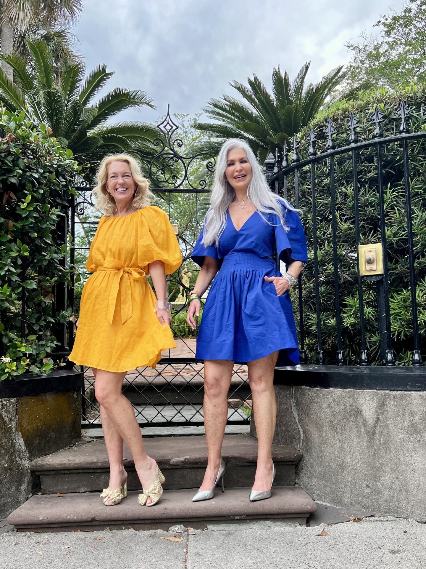 Two ladies posing in blue and gold dresses