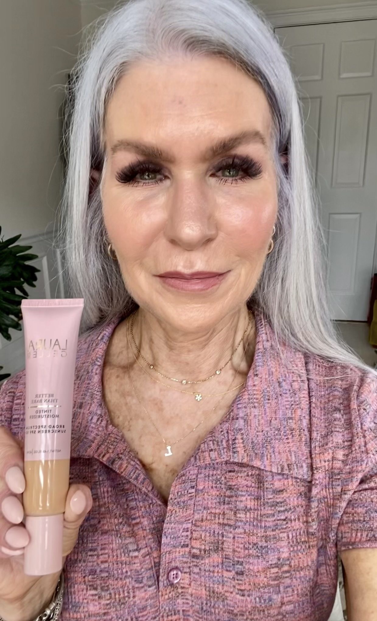 Silver hair lady holding laura gellar makeup