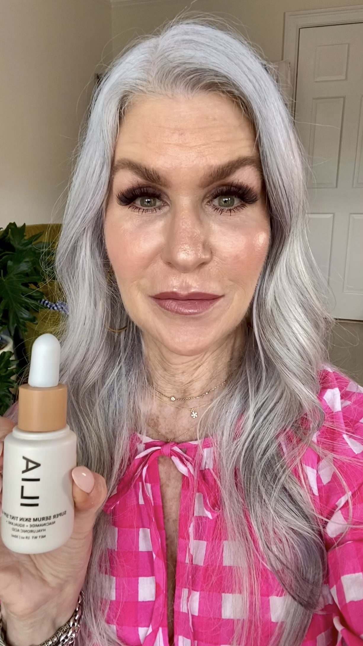 Silver hair lady holding lila makeup