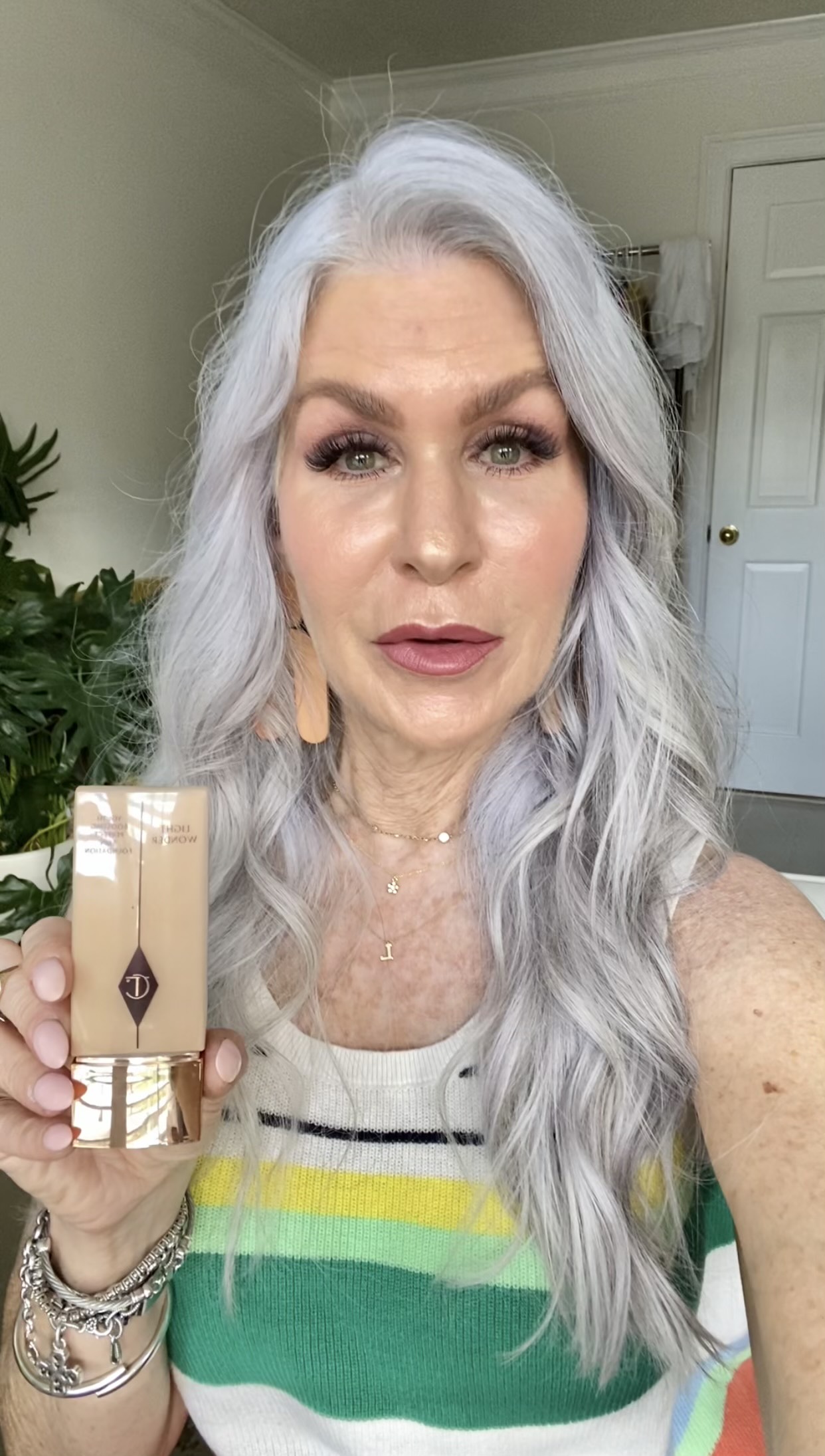 Silver hair lady holding charlotte tillberry foundation