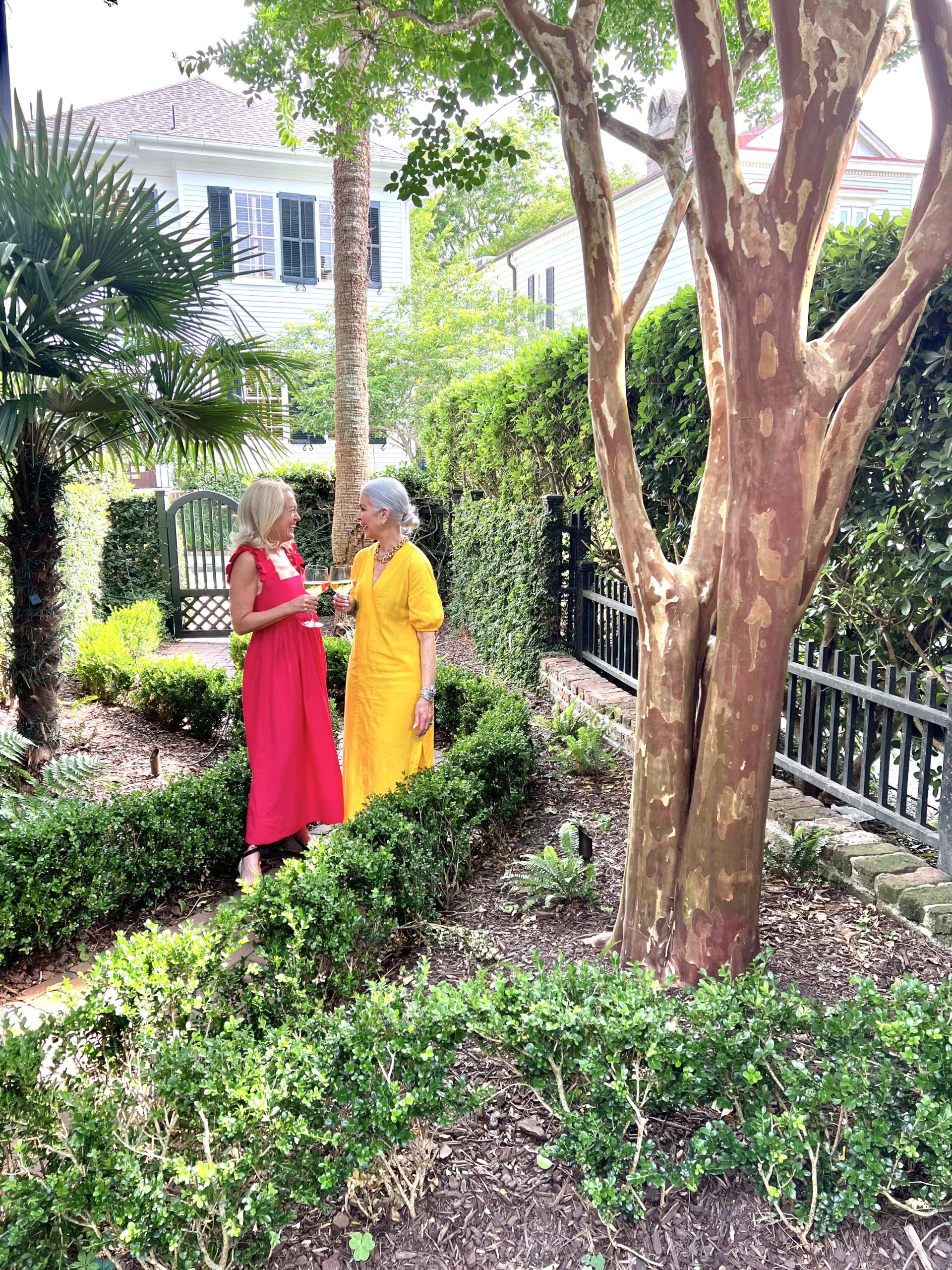 ladies wearing gold and red dresses in garden