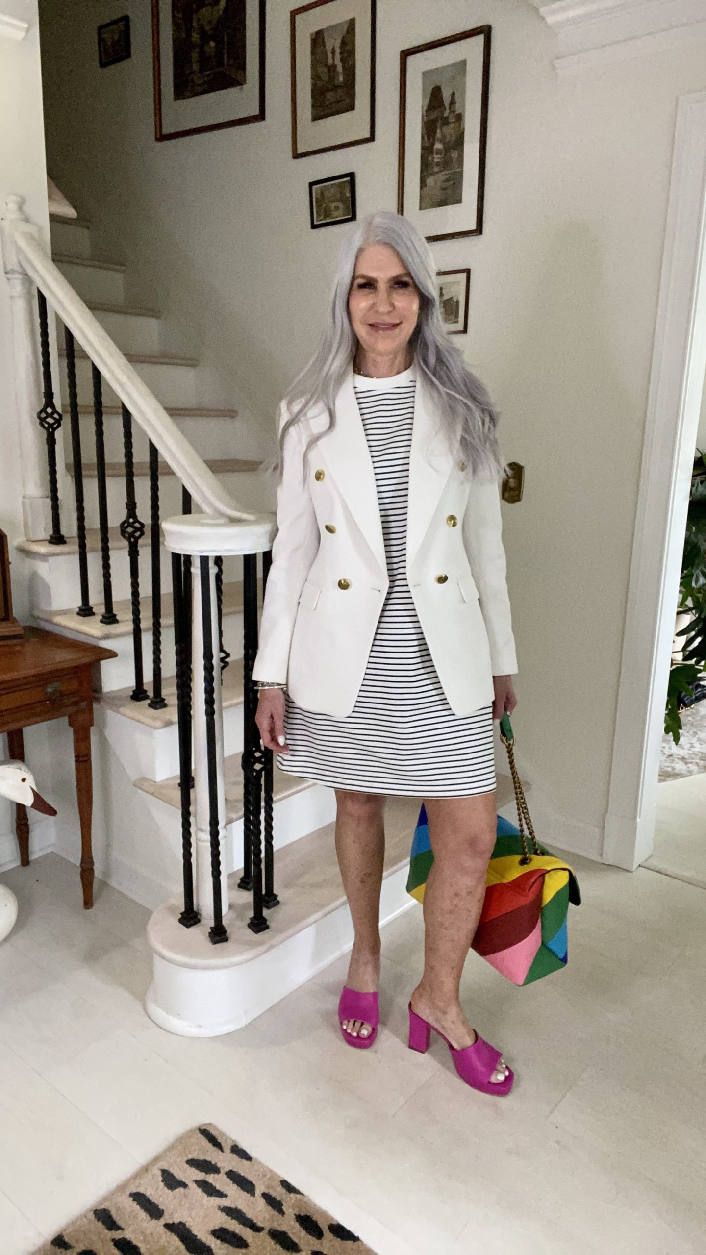 lady wearing stripe t shirt dress with white blazer and rainbow color purse