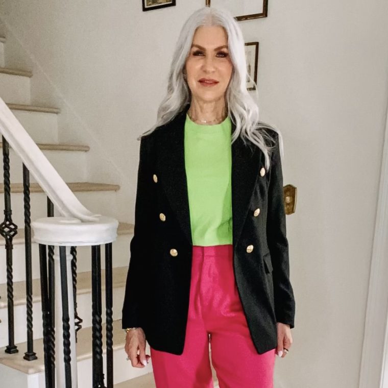 silver hair lady wearing black blazer pink pants and lime green shirt