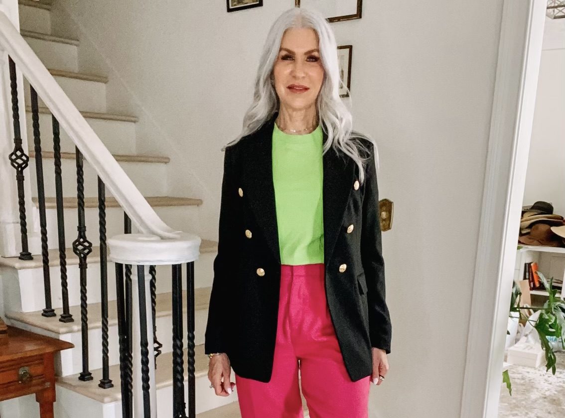silver hair lady wearing black blazer pink pants and lime green shirt