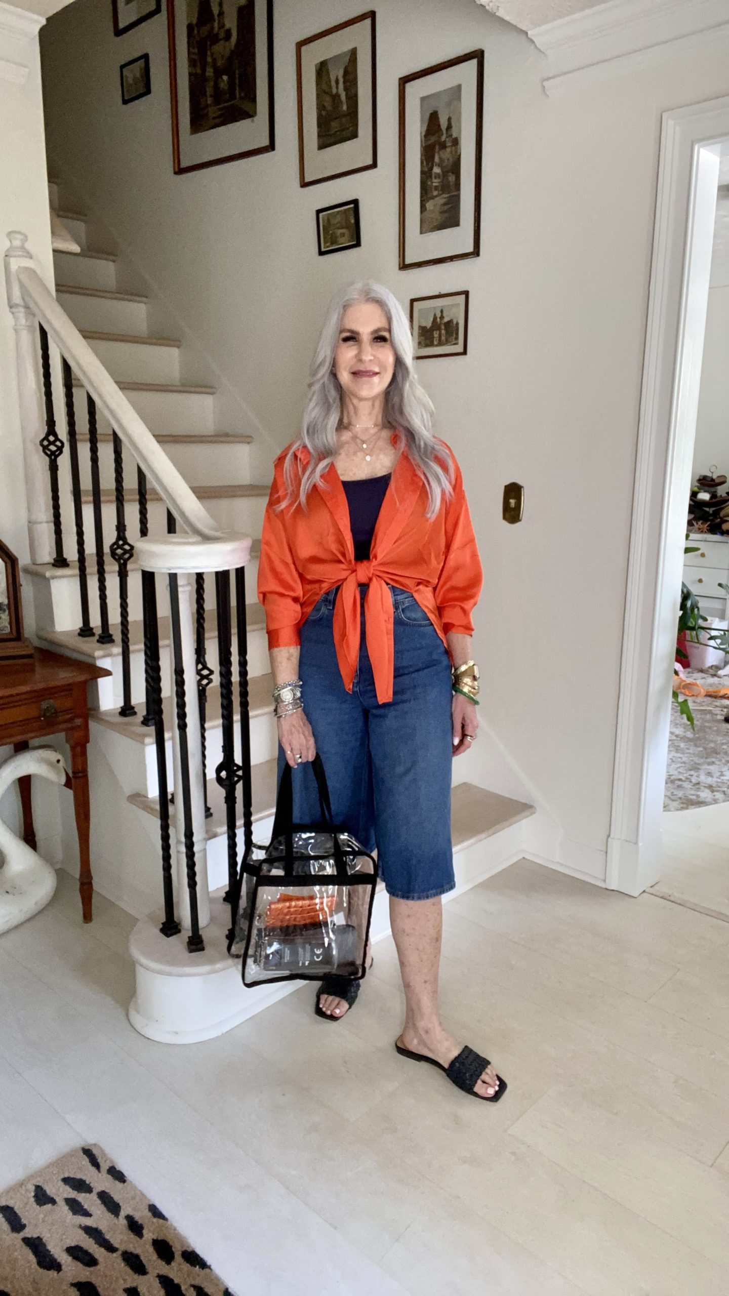 silver hair lady wearing blue jeans and orange shirt