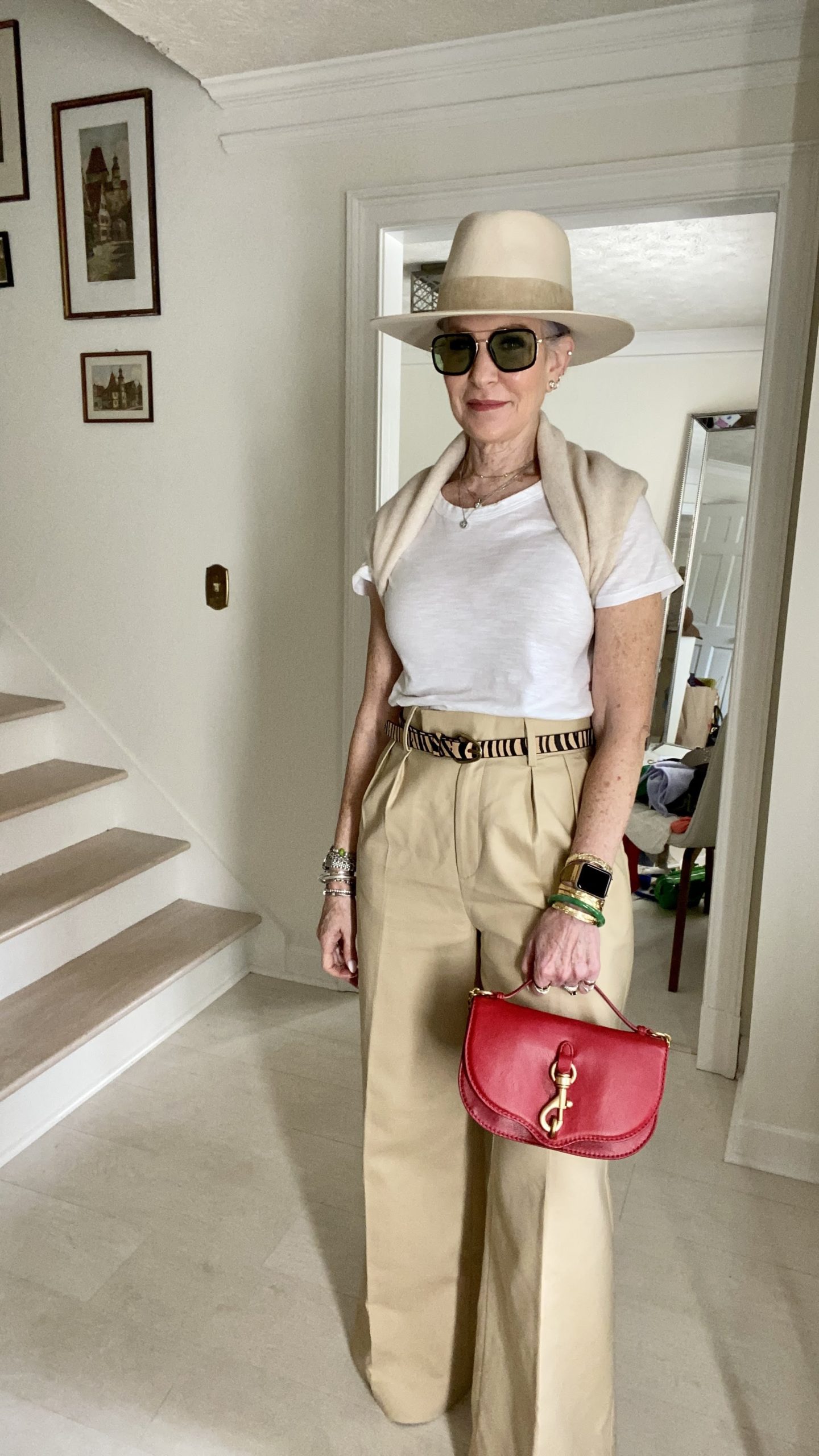woman wearing hat, black sunglasses and red purse