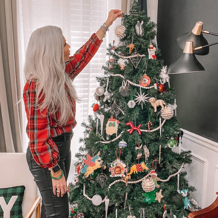 woman putting ornament on Christmas Tree