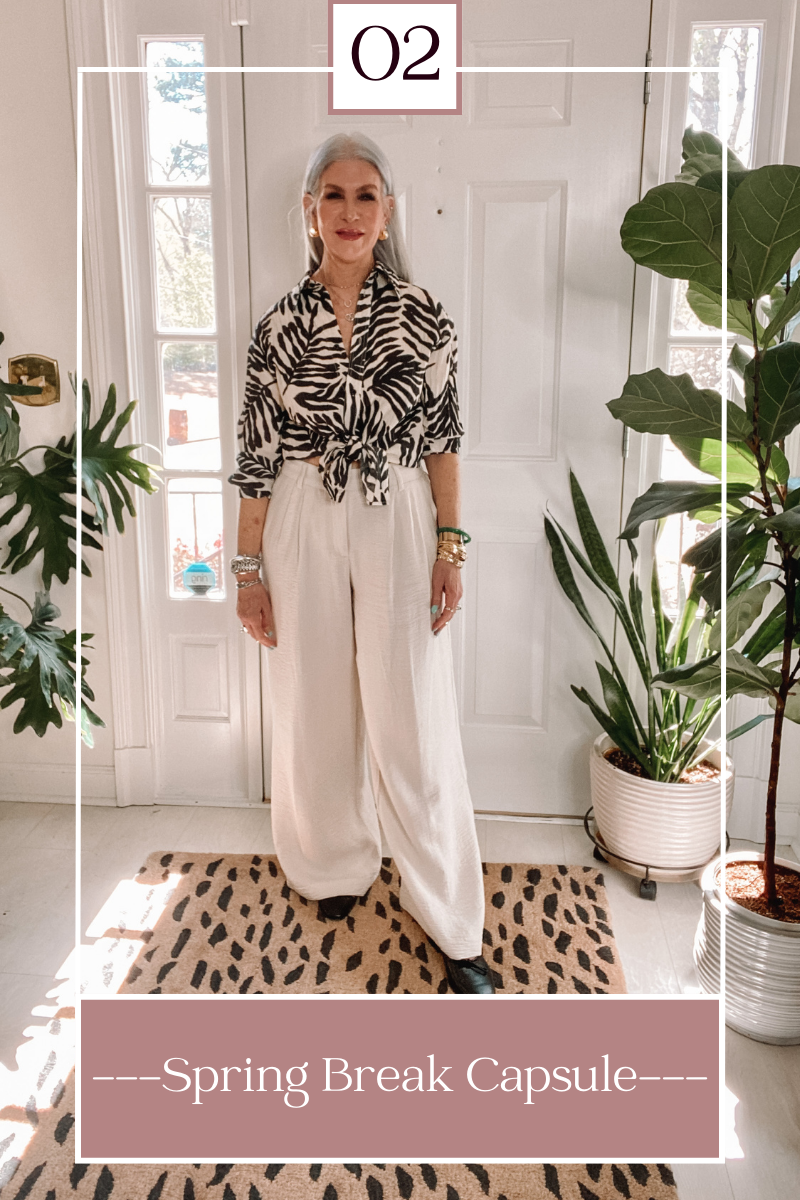 silver hair lady wearing black and white patterned blouse and white pants